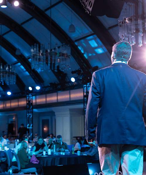 Jason is speaking in front of a crowd at an event.