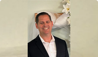 Jason Dennen wearing formal attire and smiling