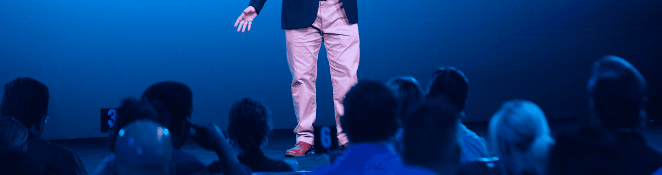 Jason is speaking in front of a crowd at an event.