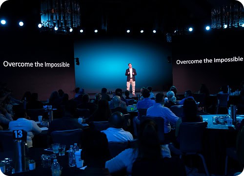 Jason is speaking in front of a crowd at an event.